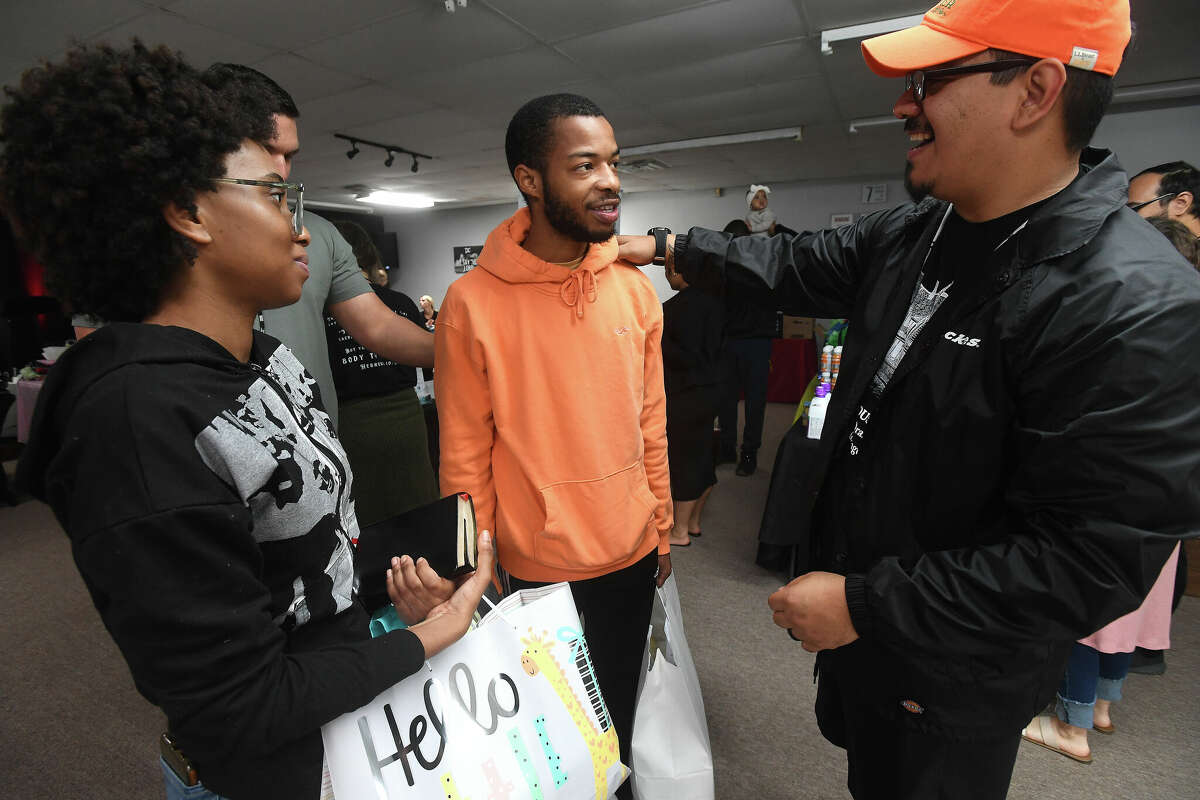 Apryl Young looks on as Pastor Johnny Asevedo talks with Keith Vallair, the father of the couple's first baby, during the 2nd Annual Orange County Community Baby Shower at Destiny Church in Orange. Photo made Saturday, April 8, 2023 Kim Brent/Beaumont Enterprise