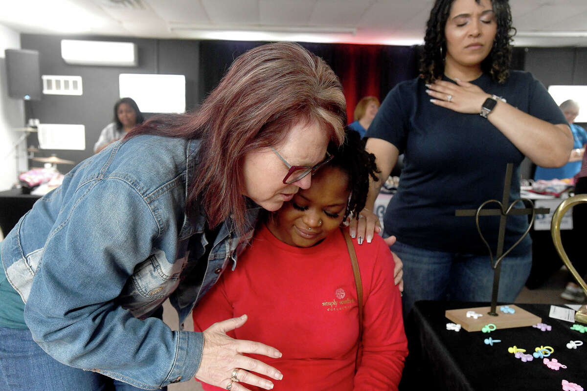 Donna Wells (left) and Tiffany Buckley with Wells of Agape, pray over Kimberly Wrighting, who is pregnant with her fifth child, during the 2nd Annual Orange County Community Baby Shower at Destiny Church in Orange. Photo made Saturday, April 8, 2023 Kim Brent/Beaumont Enterprise