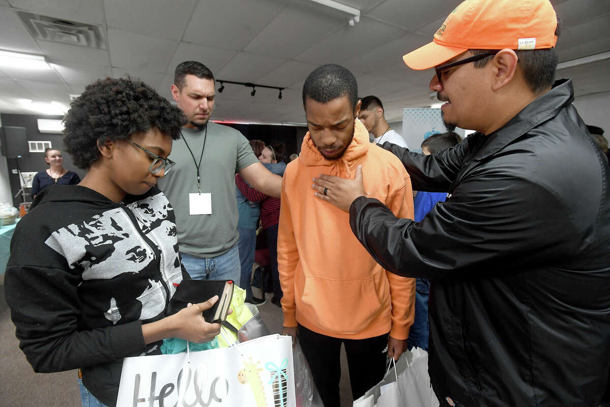 Apryl Young holds on to her Bible as Pastor Johnny Asevedo (right) prays for strength for Keith Vallair, the father of the couple's first baby, during the 2nd Annual Orange County Community Baby Shower at Destiny Church in Orange. Photo made Saturday, April 8, 2023 Kim Brent/Beaumont Enterprise