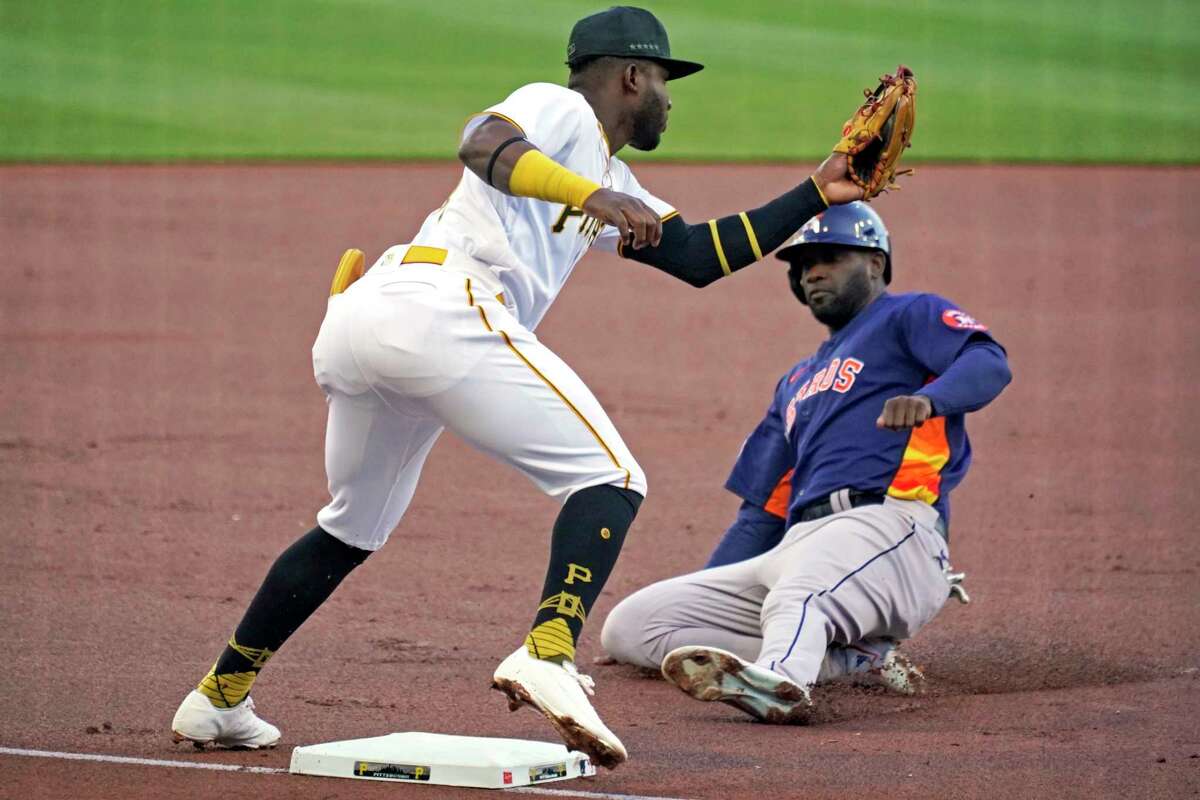Pittsburgh Pirates shortstop, left, takes the throw at third base before tagging out Houston Astros' Yordan Alvarez, right, on the front end of a double steal during the first inning of a baseball game in Pittsburgh, Monday, April 10, 2023.