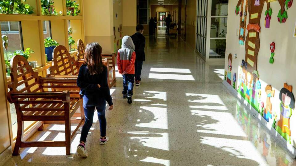 Students walk past a window in the hallway at Highland Heights Elementary on Tuesday, April 11, 2023 in Houston.