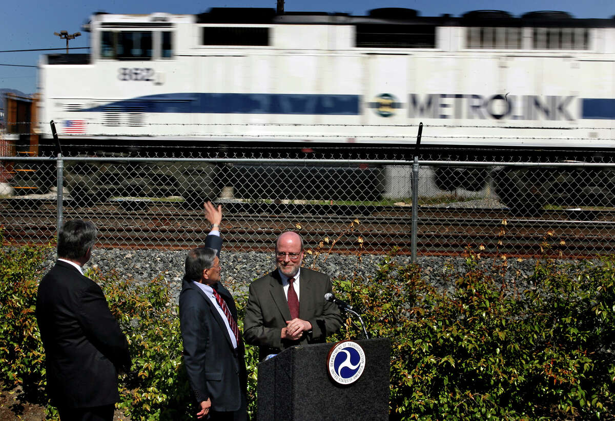 FILE: (L to R) Federal Railroad Administrator Joe Boardman, U.S. Secretary of Transportation Norman Y. Mineta, and Metrolink CEO David Solow take a break from a press conference March 23, 2006, to wait for a passing Metrolink train to pass.