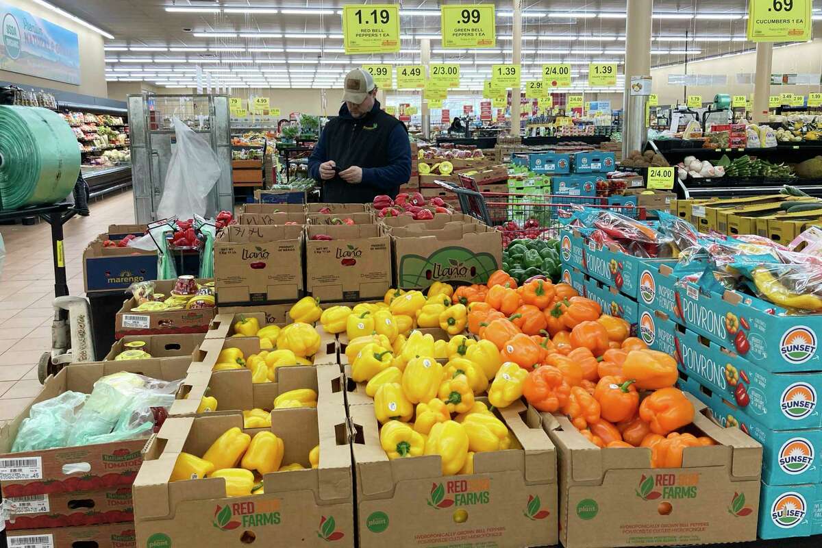 A man looks at his mobile phone while shopping at a grocery store in Buffalo Grove, Ill., Sunday, March 19, 2023. On Wednesday, the Labor Department reports on U.S. consumer prices for March.