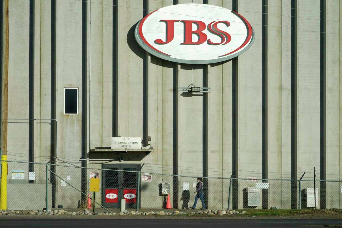 FILE - A worker heads into the JBS meatpacking plant in Greeley, Colo., on Oct. 12, 2020. The Biden administration is urging U.S. meat processors Wednesday, April 12, 2023, to make sure children aren't being illegally hired to perform dangerous jobs at their plants. The call comes after an investigation found that one of the country's largest food safety cleaning service providers employed more than 100 children as young as 13 in dangerous jobs at 13 meat processing plants in eight states, including JBS.