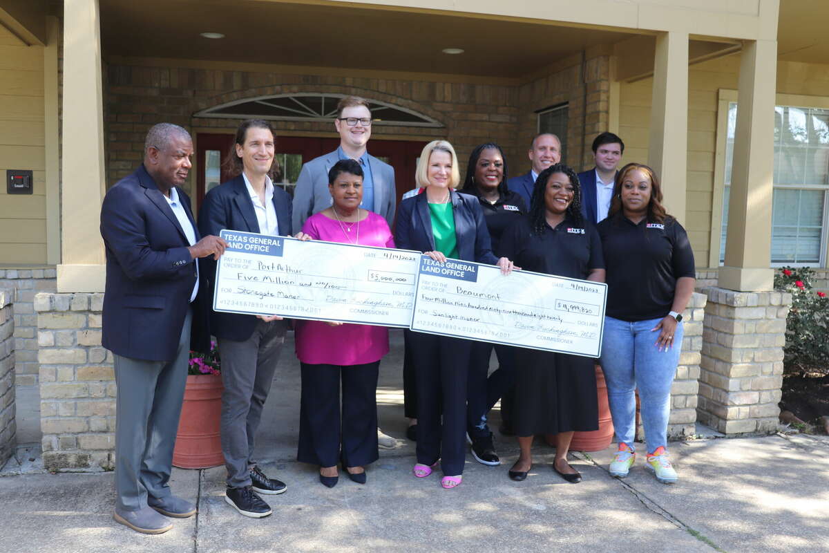 Local officials, representatives for state officials, local residents and Texas Land Commissioner Dawn Buckingham pose for a group photo with checks granted for Tropical Depression Imelda damage to Jefferson County on April 14, 2023 at the Sunlight Manor Apartments.
