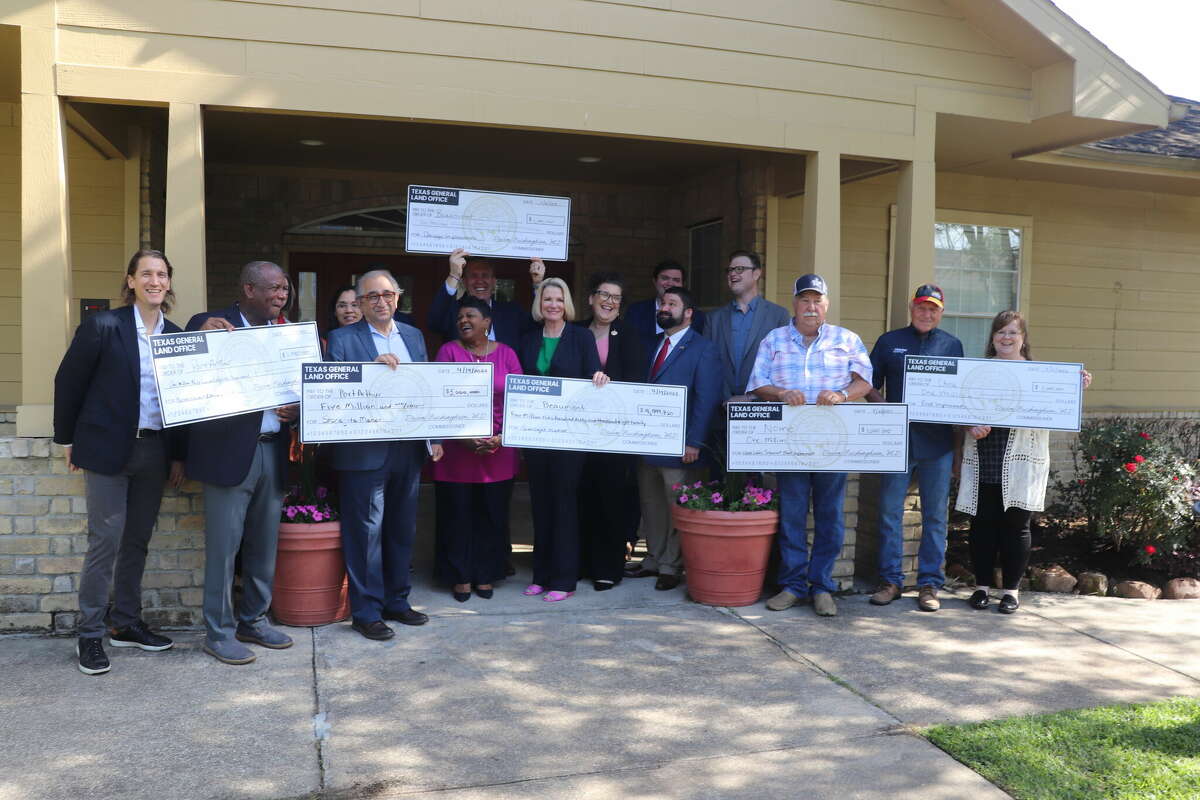 Local officials, representatives for state officials, local residents and Texas Land Commissioner Dawn Buckingham pose for a group photo with checks granted for Tropical Depression Imelda damage to Jefferson County on April 14, 2023 at the Sunlight Manor Apartments.