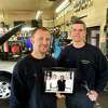 2012年2月10日星期五，在丹伯里的布莱克曼汽车公司，t·j·布莱克曼(左)和他的父亲吉姆站在一张展示三代人所有权的照片前。
