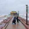 Spectators look out towards the Gulf of Mexico as the outer bands of Hurricane Delta make landfall in Galveston, Texas on October 9, 2020.
