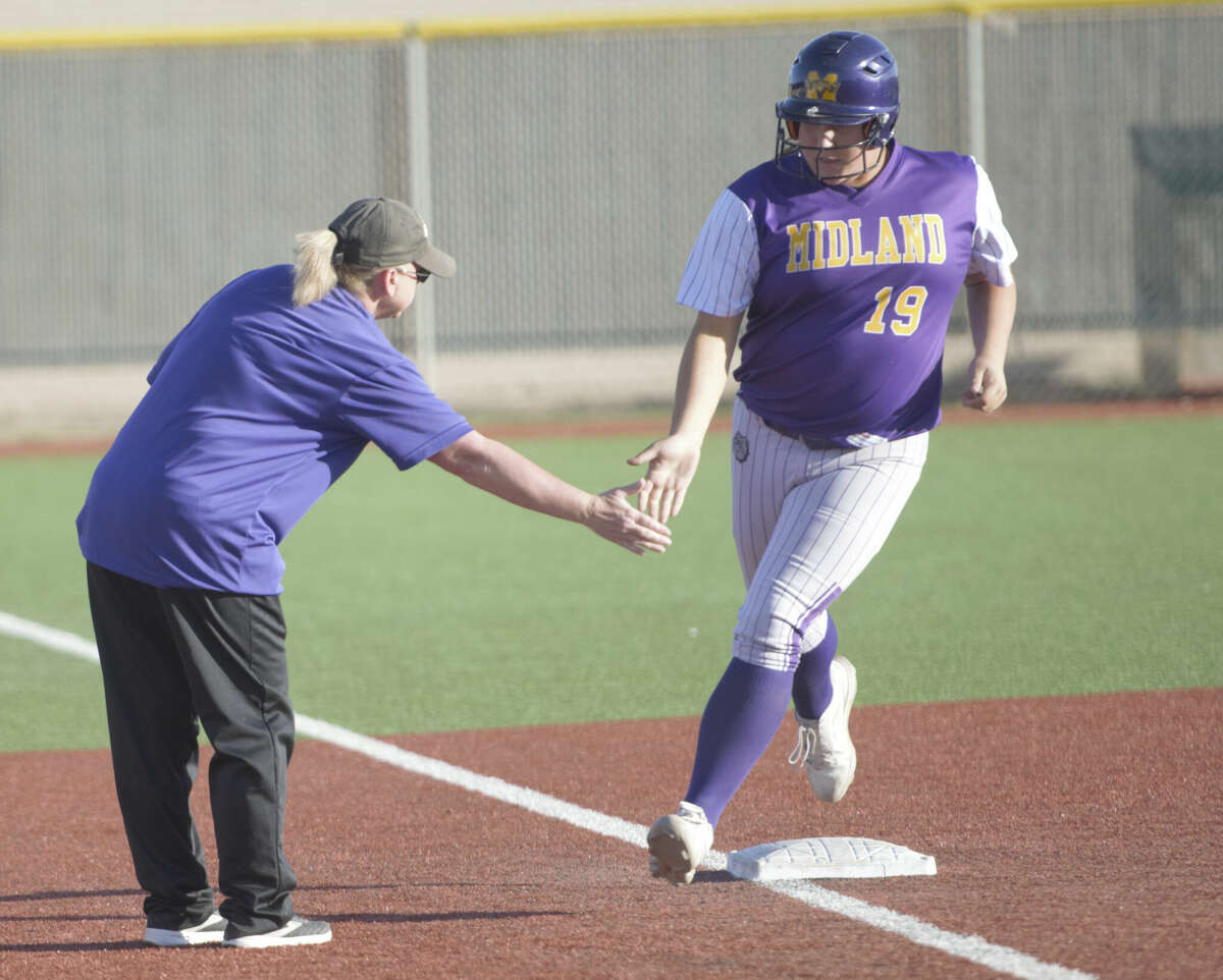 Midland High's Sadie Ryan gets a hand from head coach Shawnda Vines as she rounds third after hitting a two-run homer against Legacy, April 18 at Gene Smith Field. 