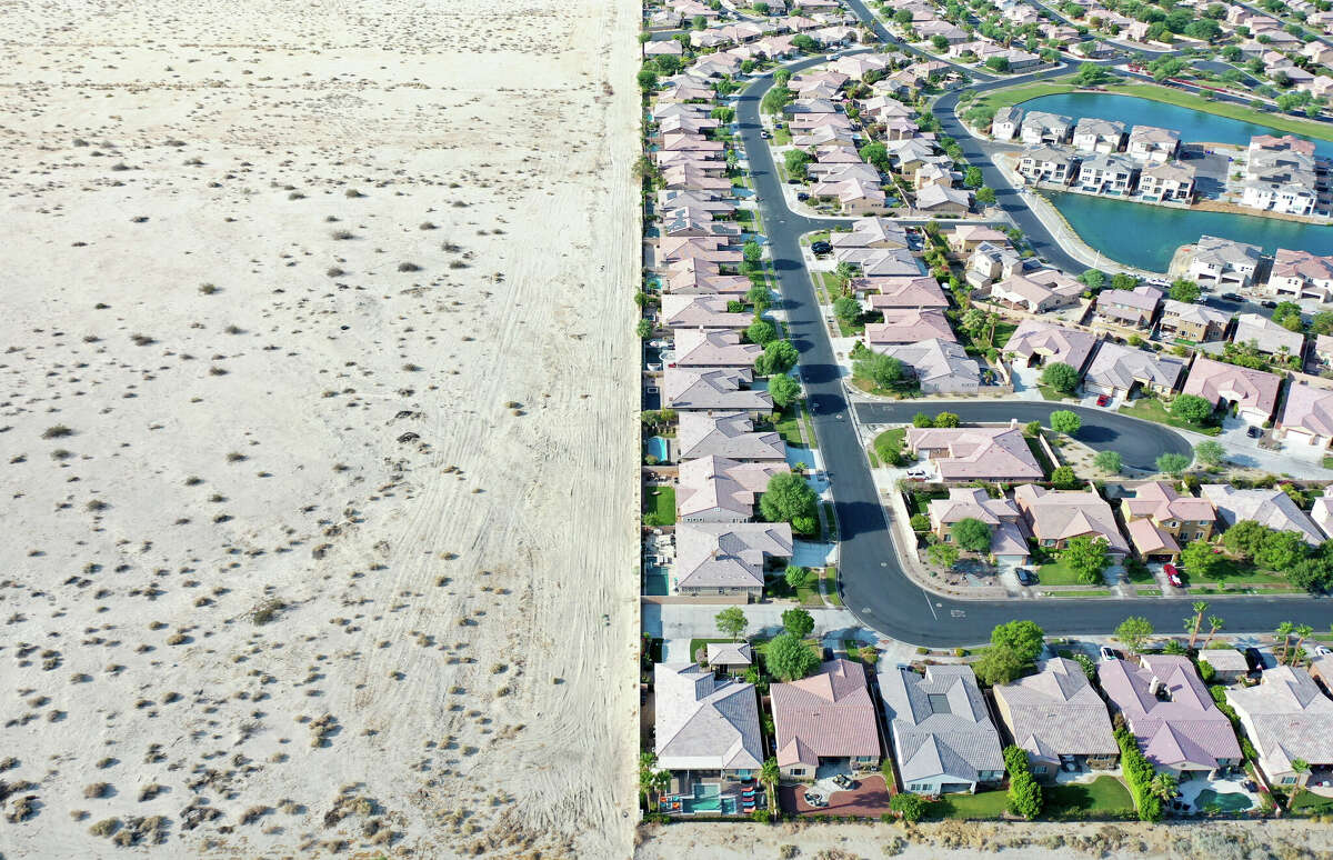 FILE: An aerial view of homes next to undeveloped desert on July 13, 2022, in Indio, Calif.