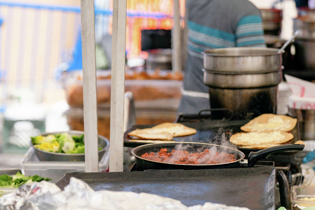 Meat and tortillas being cooked and prepared at the Primavera stall at the Ferry Building Farmer's Market on Saturday, April 15, 2023.