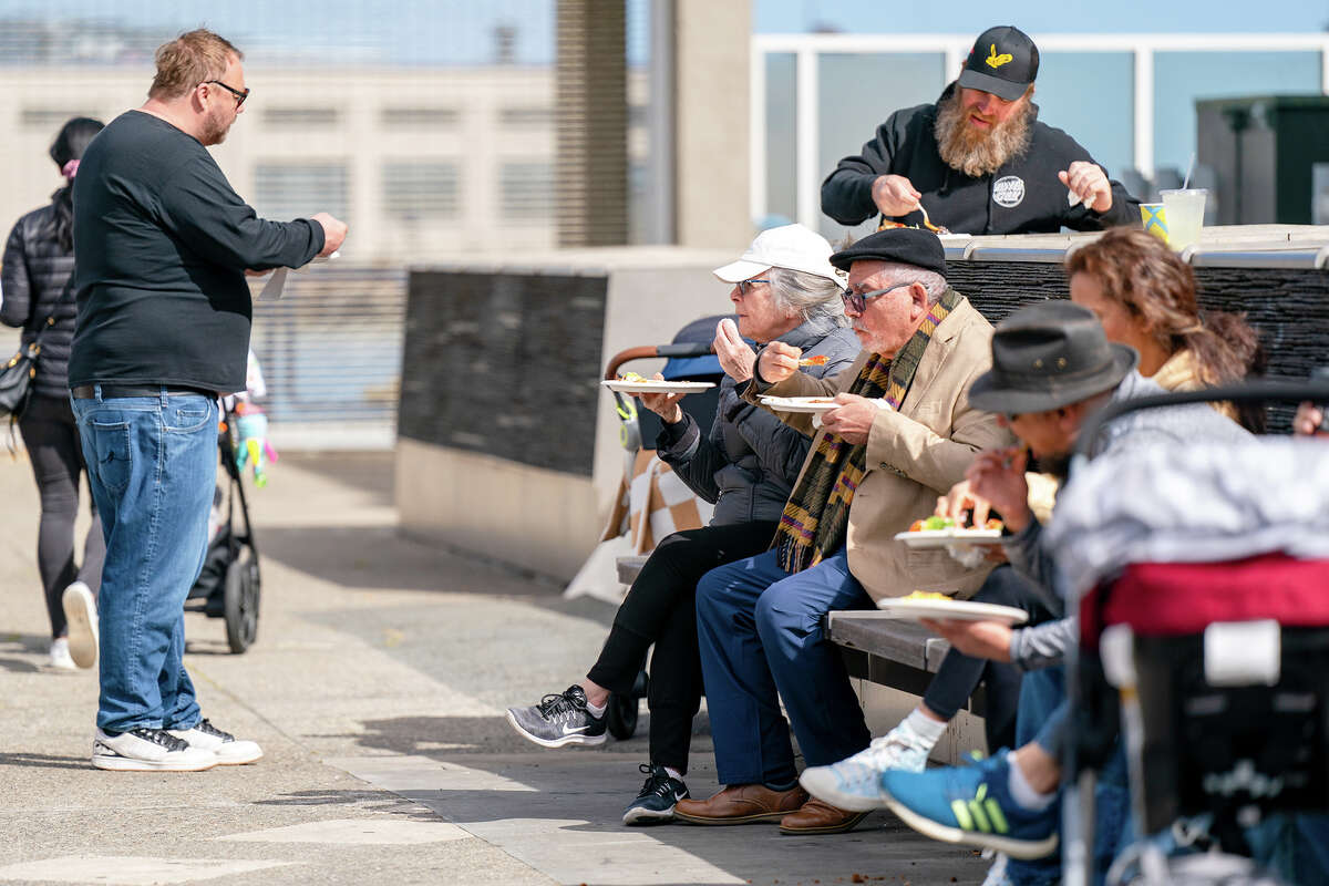 Customers sit close to the Primavera stall and enjoy their food at the Ferry Building Farmer's Market on Saturday, April 15, 2023.