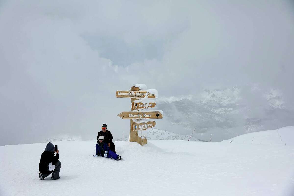 3月30日，一个家庭在内华达山脉的猛犸山滑雪胜地的白雪皑皑的山顶拍照。该州巨大的积雪刚刚开始融化。