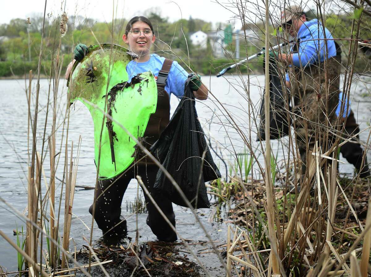 Emelia Hevenstone, 15, of Stratford, part of the Beardsley Zoo's Conservation Discovery Corps program for high schools, removes a broken sled from Bunnell's Pond as part of an Earth Day clean up at Beardsley Park in Bridgeport, Conn. on Saturday, April 22, 2023.