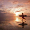 The file photo above shows a young surfer running with his board in hand.