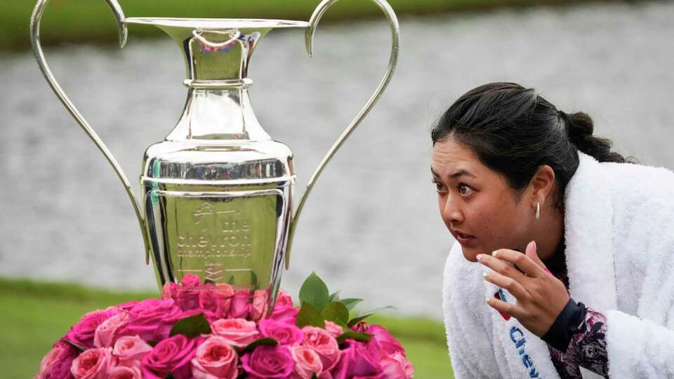 Lilia Vu looks at her reflection in the Dinah Shore Trophy after winning the Chevron Championship women's golf tournament in a playoff over Angel Yin at The Club at Carlton Woods on Sunday, April 23, 2023 in The Woodlands.