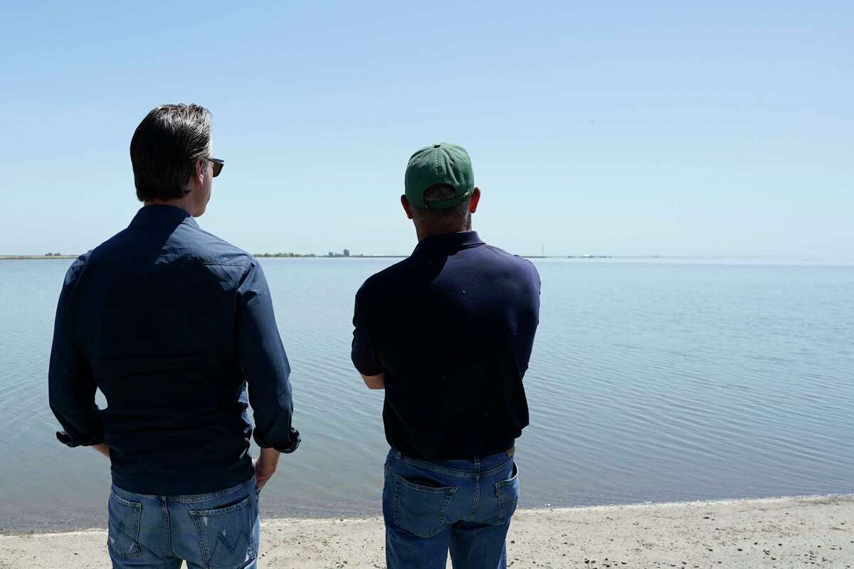 Gov. Gavin Newsom (left) takes a tour of Tulare Lake with Erik Hansen, owner of Hansen Ranches, on Tuesday.