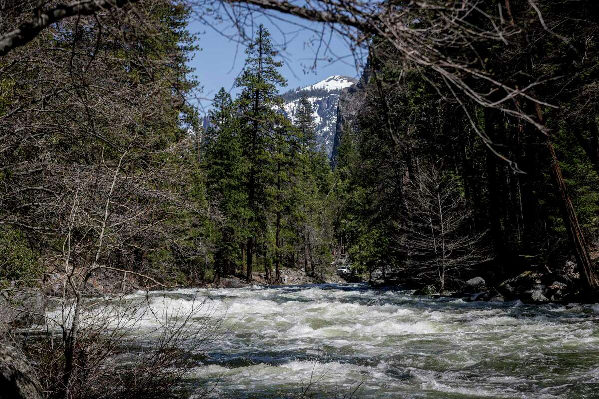 The Merced River flows through Yosemite National Park on Tuesday. The river is expected to flood in certain areas by the end of the week, prompting the closure of Yosemite Valley.