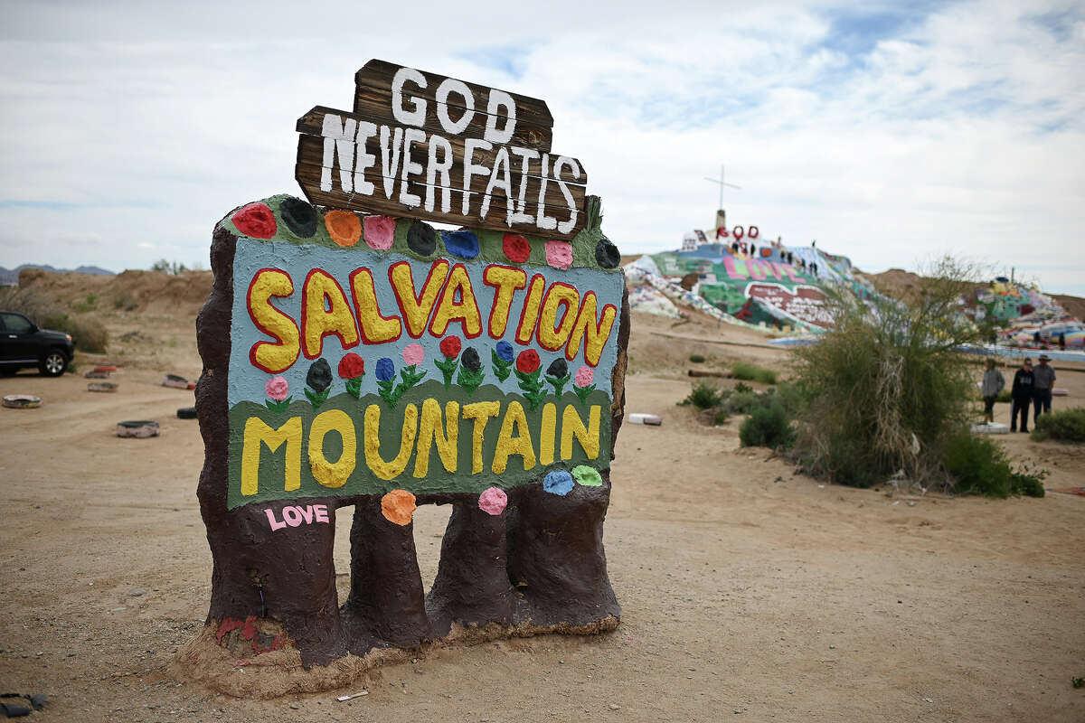 A sign marks the entrance to Salvation Mountain, a hillside covered with biblical messages and symbols built over a 30-year period by outsider artist and Vermont native Leonard Knight, in Slab City, Calif., about 50 miles north of the US border with Mexico, on March 10, 2019.