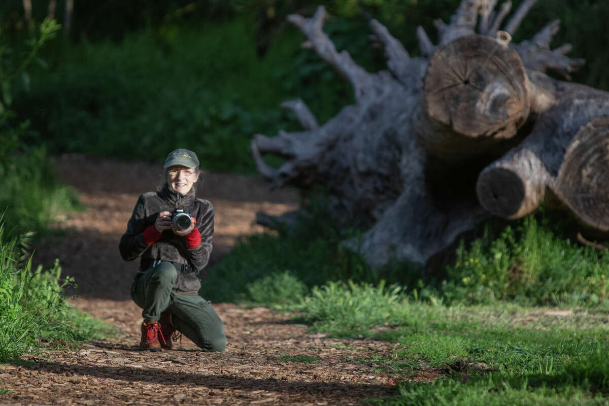 Janet Kessler poses while photographing coyotes at Golden Gate Park on April 27, 2023 in San Francisco, California.  Kessler has been taking pictures of the coyotes in the park for years.