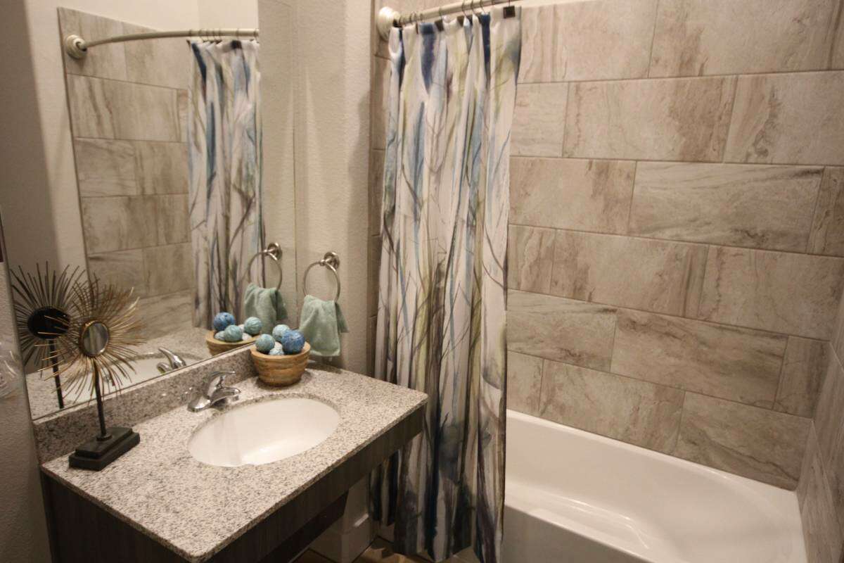 The bathrooms accented bathtub tiles add a more contemporary touch. 