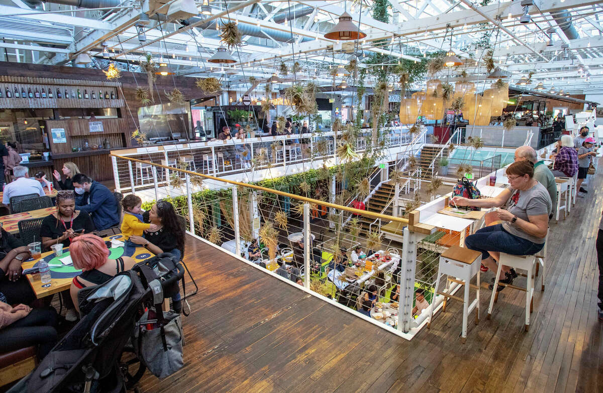 Diners sit along the railing on the upper level of the Anaheim Packing House in Anaheim, Calif. The site of a former orange-processing plant is now a food hall.