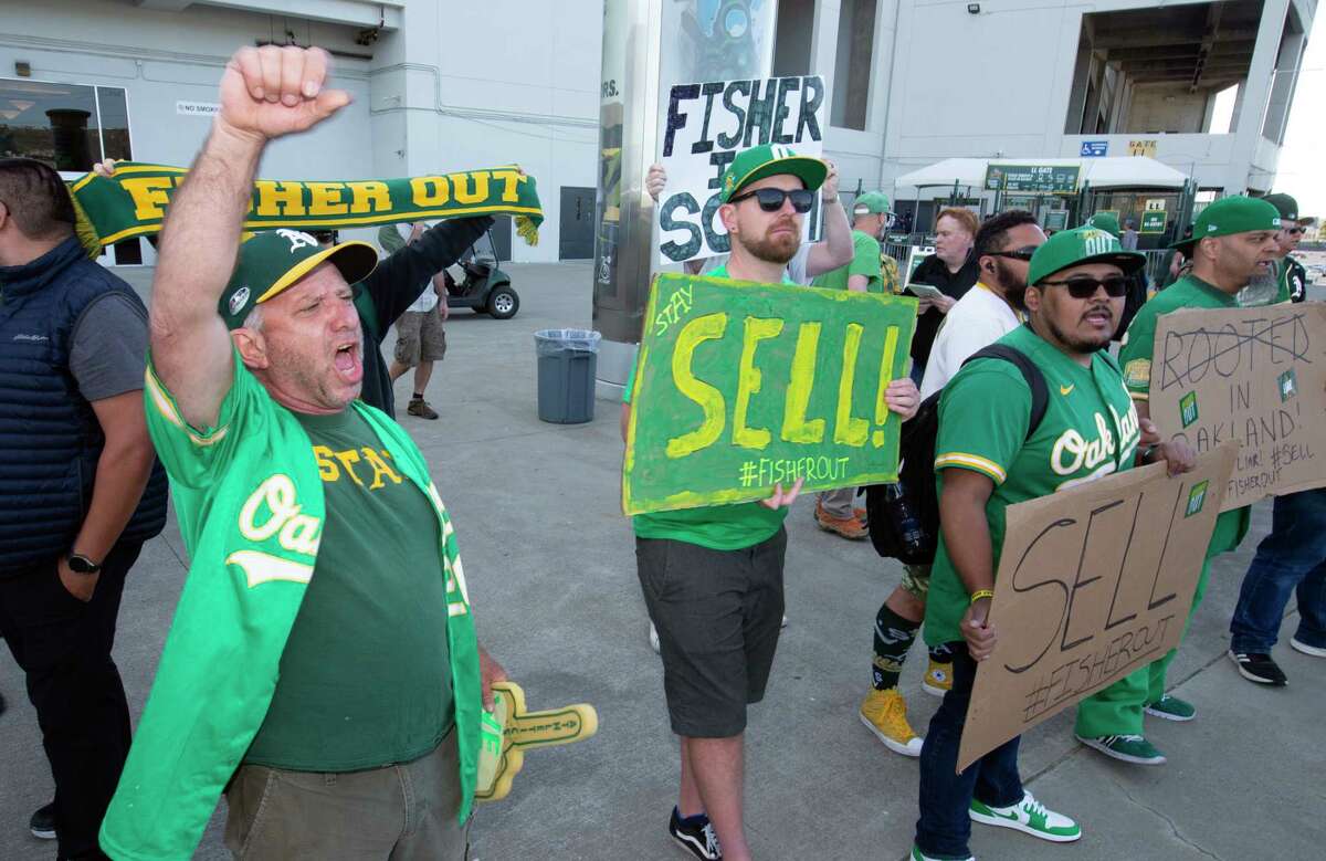 Oakland Athletics fans hang signs at RingCentral Coliseum to protest the  team's potential move to Las Vegas and to call for team owner John Fisher  to sell the team during a baseball