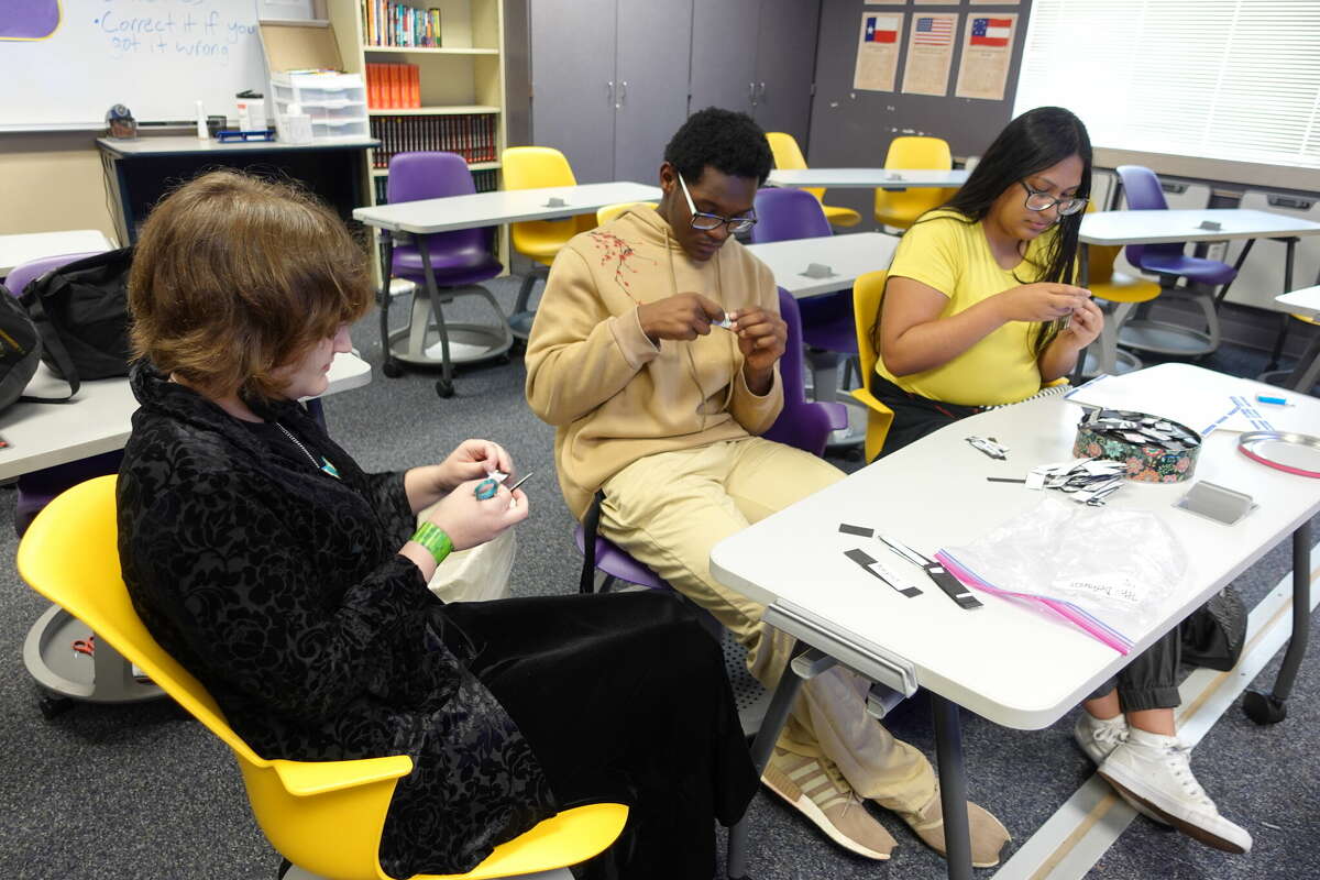 Sabine Pass juniors Sophie Tarver, left, Alexander Jackson, center, and Lashly DeLuna, right, create magnets to use for a timeline to study for the upcoming UIL State Social Studies meet. Photo taken April 26, 2023. Photo by Olivia Malick/ The Enterprise.
