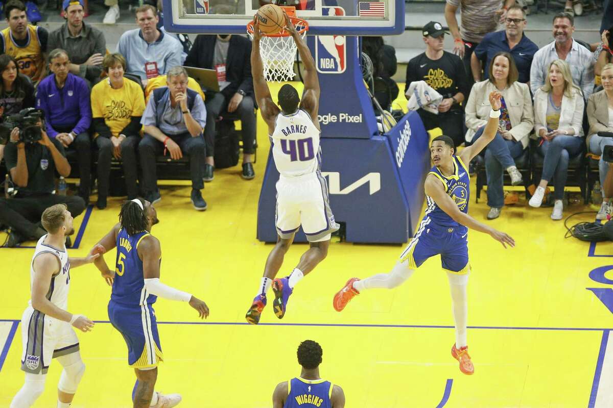 Kings forward Harrison Barnes dunks as Warriors guard Jordan Poole soars past him Friday in the first half of Game 6 of the team’s first-round series. 