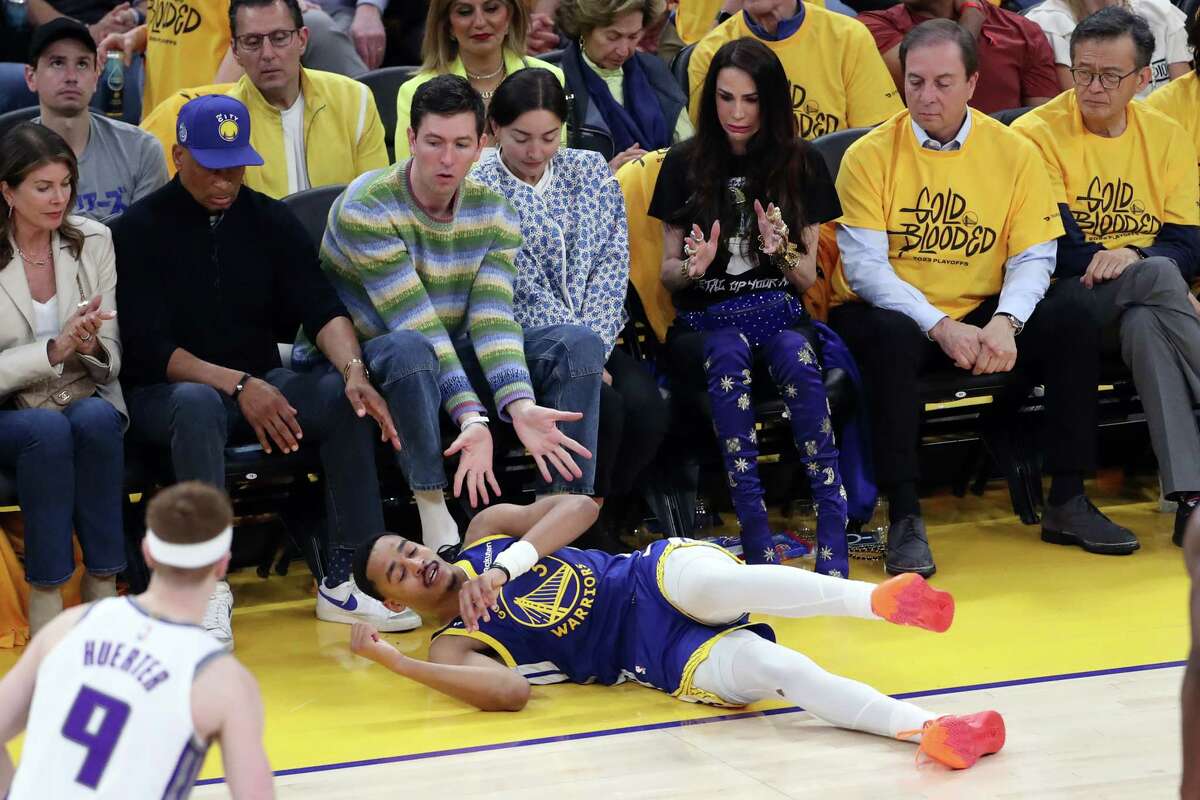 Actor Nicholas Braun, aka Cousin Greg from “Succession,” tries to protect Warriors guard Jordan Poole after Poole fell during the fourth quarter of Golden State’s 118-99 loss to the Kings on Friday. 