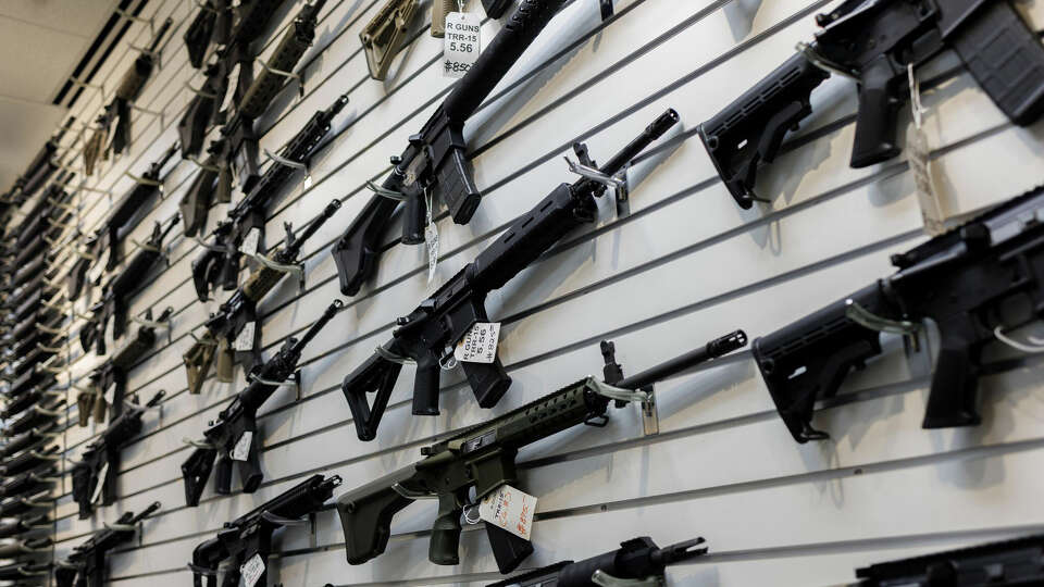 A selection of AR-15-style rifles hangs on a wall at R-Guns store on Jan. 11, 2023, in Carpentersville, Illinois, a day after the state banned them. On Tuesday, Washington became the 10th state to ban the rifles. (Armando L. Sanchez/Chicago Tribune/TNS)