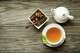 Cup of tea with dry green tea collection on wooden table