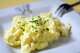 A plate of creamy scrambled eggs decorated with a sprinkling of chives.