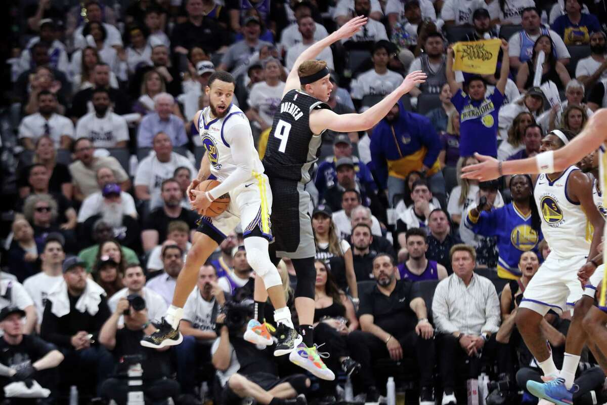 Warriors guard Stephen Curry, who scored 50 points, grabs an offensive rebound away from Sacramento’s Kevin Huerter in the pivotal third quarter.
