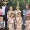 Rabbi Shimon Gruzman, (far left, holding baby) and Chanie Gruzman (far right holding baby) along with their four sets of twins. 