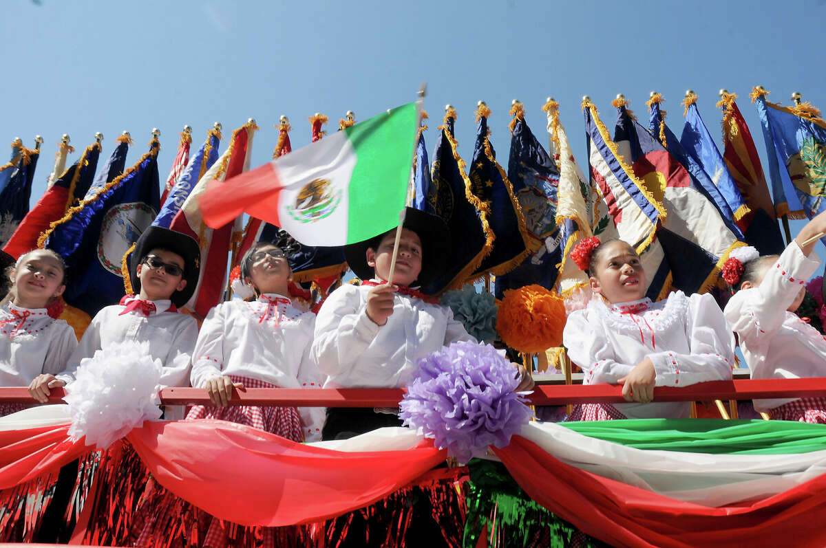 年次LULAC Cinco de Mayo Paradeで服を着た子供たちが旗を振っています。 