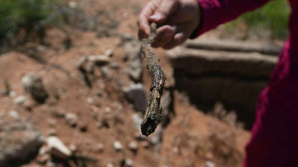 Hawk Dunlap shows a stick, reeking of crude oil after dipping it until an improperly plugged well on Antina Ranch on Tuesday, April 25, 2023 near Monahans.