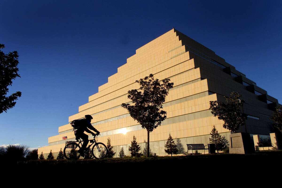 A cyclist rides by a building known as “the Ziggurat,” which houses state government offices in Sacramento. 