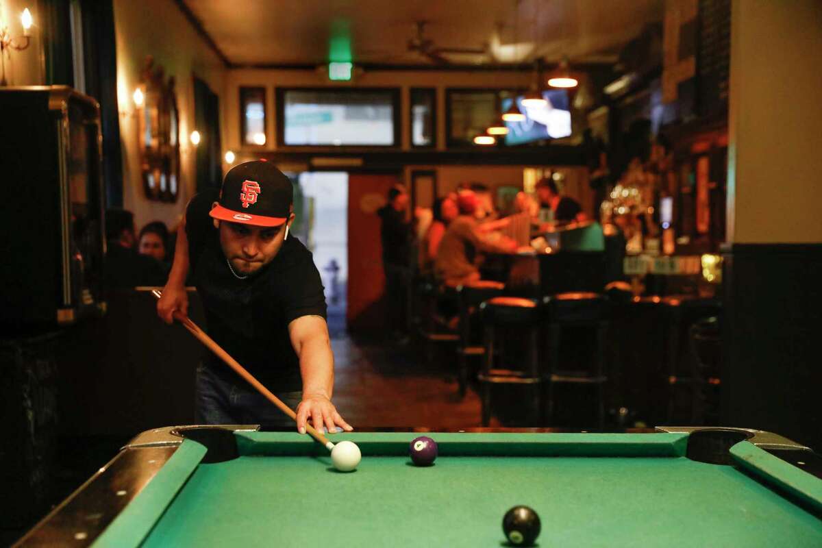 2018年，塞尔吉奥·维拉纽瓦(Sergio Villanueva，头戴SF棒球帽)在教会区的潜水酒吧Wooden Nickel打台球。