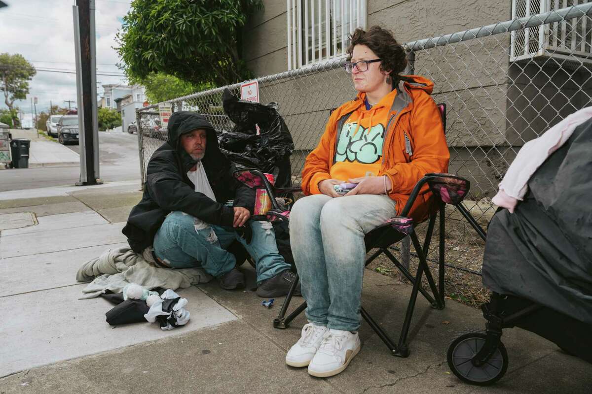 5月1日星期一，Missy Krisik(右)和Zachary Ylitalo坐在加州旧金山教会区的Shotwell街营地附近。旧金山无家可归者:这是阻碍特派团小房子的原因。