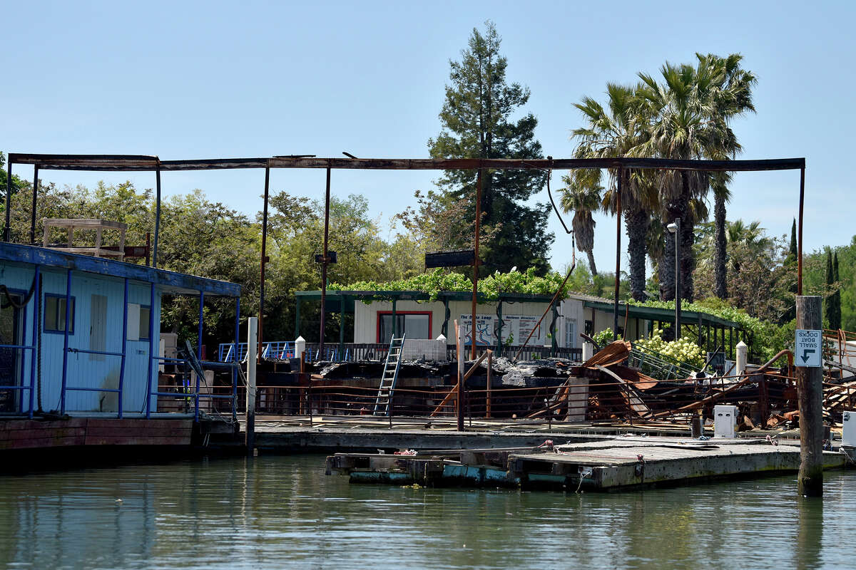 The burnt remains of Moore’s Riverboat Restaurant, which was destroyed in an arson incident last summer, as seen from the water on Thursday, April 27, 2023. 