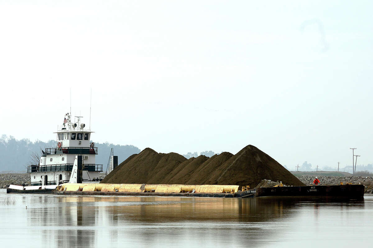 FILE: A barge loaded with dirt is moved down the Mokelumne River, where it will be used to help to patch a crater on the Tyler Island levee, near Isleton, Calif. 