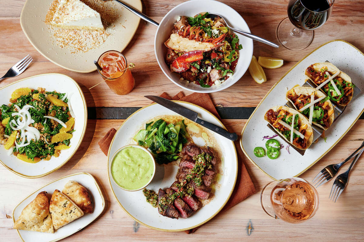 On the table are Monkeypod Kitchen's bulgogi pork tacos, prime rib-eye steak, coconut cream pie, organic kale salad, and fish and lobster pasta.