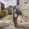 2023年5月1日，星期一，约翰·布莱克本站在加州旧金山诺埃谷地震棚屋外的肖像前。