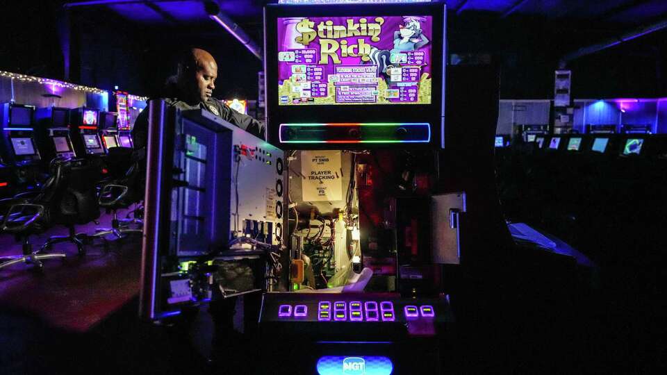 A law enforcement officer opens a machine during a game room operation in Harris County. A reader has concerns about the push for casinos in Texas.