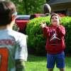 Conner Curran, 12, right, plays catch football with his brother William, 10, at their home in Ridgefield, Conn. on Tuesday, May 9, 2023. Conner is receiving gene therapy treatment for his Duchenne's muscular dystrophy.