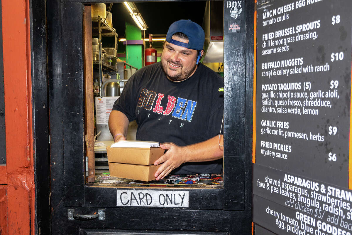 Cole G. brings another ready order to The Box window outside Tempest bar, on Sunday night, May 7, 2023.