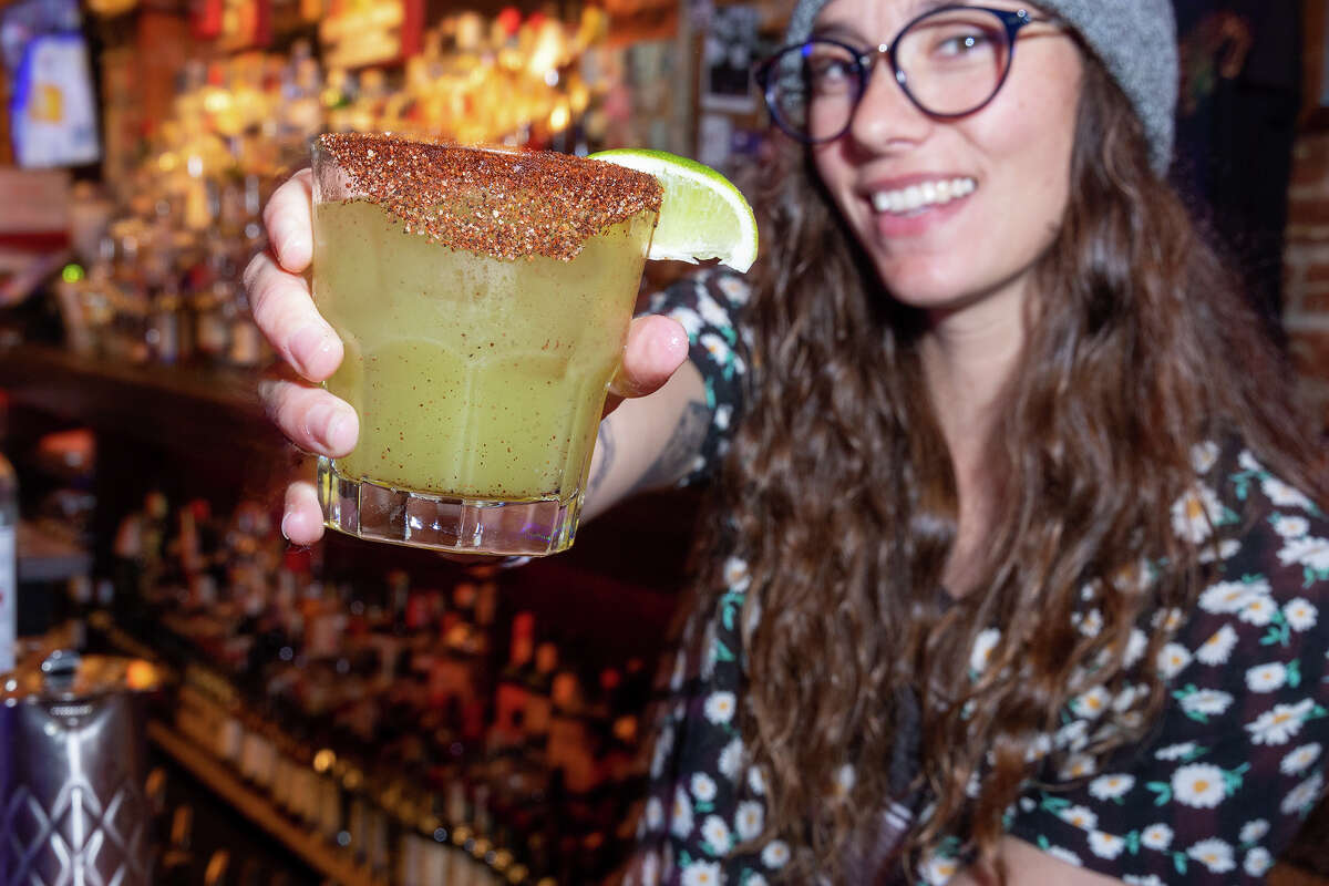 Alessandra Goldsborough of San Francisco hands over a fresh Tempest Mezcal Margarita at the South of Market (SOMA) District bar on Sunday night, May 7, 2023.