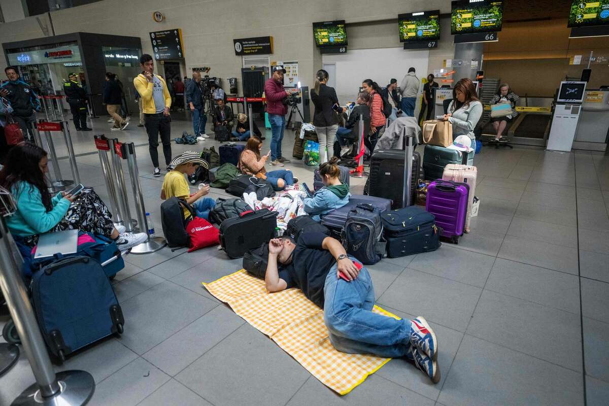 People lie on the floor after their flights were canceled at the El Dorado International Airport in Bogota on Feb. 28, 2023. 