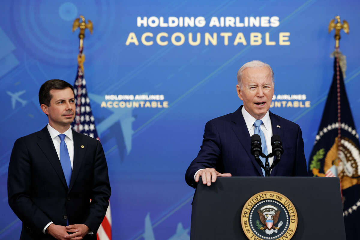 U.S. President Joe Biden speaks as Transportation Secretary Pete Buttigieg looks on during an announcement of new airline regulations on May 8, 2023, in Washington.